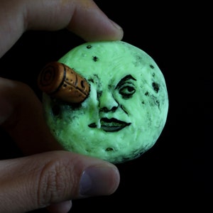 Trip to the moon glows in the dark as figure, pin, magnet.