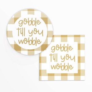 May include: Two printable Thanksgiving-themed gift tags with a gold and white buffalo plaid pattern. The text on the tags reads "gobble till you wobble".