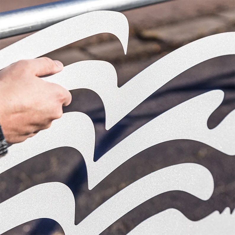 Pu&ograve; includere: Un film per finestre bianco satinato con un design ondulato. Il film viene applicato a una finestra.