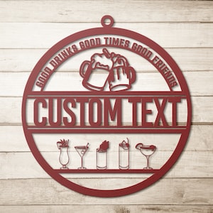 Pu&ograve; includere: Un cartello circolare in metallo rosso con il testo "Good Drinks Good Times Good Friends" e "CUSTOM TEXT" al centro. Il cartello presenta due boccali di birra che brindano e una fila di sei diverse icone di bevande.
