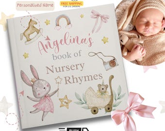 Puede incluir: Un libro de rimas infantiles personalizado con una cubierta blanca que presenta ilustraciones en acuarela de un caballito de madera, un arcoíris, un lazo rosa, una cámara, un conejo con una varita de estrella y un osito en un cochecito.