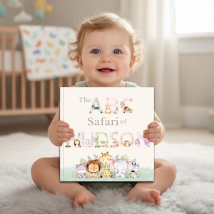 May include: A square hardcover book titled The ABC Safari of HUDSON, featuring watercolor illustrations of safari animals integrated into the letters of the title and a row of cute cartoon animals including a hippo, lion, giraffe, elephant, and zebra.