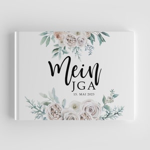 Könnte beinhalten: Weißes Gästebuch mit einem floralen Design in Grün- und Beigetönen. Der Text "Mein JGA 15. MAI 2023" ist auf der Vorderseite gedruckt.