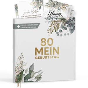 Puede incluir: Un libro de visitas blanco con letras doradas que dice "80 MEIN GEBURTSTAG". El libro está decorado con detalles florales e incluye una pila de tarjetas con la palabra "Happy" y otro texto. El libro también tiene una etiqueta.