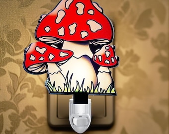 May include: A plug-in night light featuring a graphic of three mushrooms with bright red caps and white spots. The mushrooms have cream-colored stems and are situated above a patch of green grass. The base is white with an on and off toggle switch.