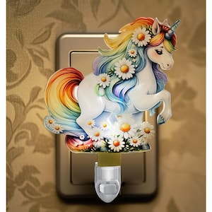May include: A whimsical night light featuring a white unicorn with a rainbow mane and tail, adorned with daisy flowers. The unicorn is set against a neutral background, with a plug-in base for easy use. The night light is designed to provide a soft, ambient glow.