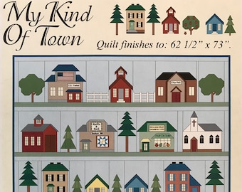 May include: A colorful quilt pattern featuring a small town with houses, a church, a grocery store, a school, and a post office. The quilt finishes to 62 1/2 inches by 73 inches.