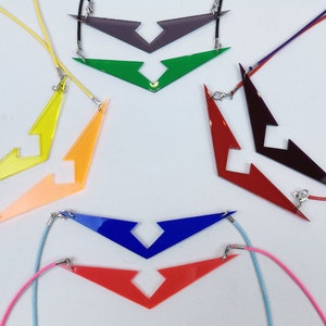May include: Seven necklaces with different colored pendants shaped like a lightning bolt with a cut-out in the middle. The pendants are in the colors red, orange, yellow, green, blue, purple, and pink.