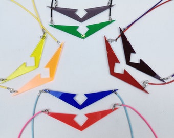 May include: Seven necklaces with different colored pendants shaped like a lightning bolt with a cut-out in the middle. The pendants are in the colors red, orange, yellow, green, blue, purple, and pink.