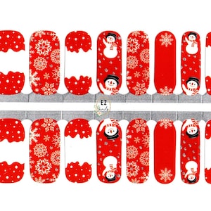 May include: Sheet of nail wraps featuring a festive winter design. The wraps showcase a red and white color scheme with patterns of snowflakes, snowmen, and polka dots. The text "EZ nails" is visible.