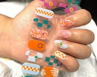 Könnte beinhalten: Nagelkunst-Aufkleber mit verschiedenen Designs, darunter Schachbrettmuster, Smiley-Gesichter und florale Akzente. Die Aufkleber sind in den Farben Rosa, Orange, Grün und Blau gehalten. Der Text "NG200293" ist auf dem Bogen zu sehen.