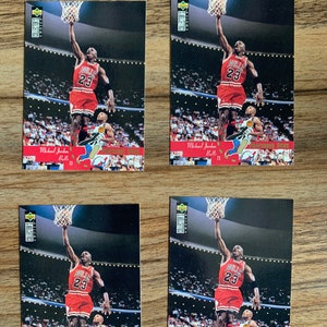 May include: Four trading cards featuring Michael Jordan, a basketball player for the Chicago Bulls, in a red and black uniform, performing a slam dunk. The cards are from the 1992-93 Upper Deck Collector's Choice series.