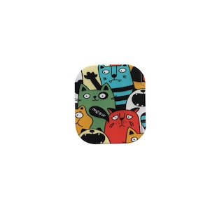 以下が含まれることがあります： カラフルな正方形の携帯電話ケースで、漫画の猫の模様が描かれています。猫は緑、青、赤、黄、黒など、さまざまな色をしています。ケースには「meow」という文字が書かれています。