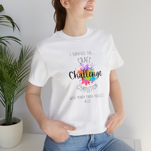 May include: White t-shirt with a colorful paint splatter design and the text "I survived the... Craft Challenge Completion with Manda Panda Projects #CCC"