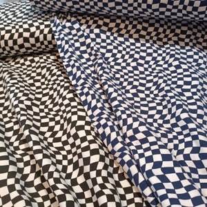 Könnte beinhalten: Zwei Stoffstücke mit einem karierten Muster. Ein Stoff ist schwarz-weiß, der andere ist blau-weiß. Beide Stoffe haben ein welliges kariertes Muster.