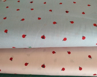 Könnte beinhalten: Zwei Stoffstücke mit Gingham-Muster. Das obere Stück ist hellblau mit weißem Gingham und roten Marienkäfern. Das untere Stück ist rosa mit weißem Gingham und roten Marienkäfern.