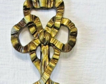 May include: Gold-toned wall sconce with a mirror and two candle holders. The sconce is decorated with a large, ornate bow and floral accents.