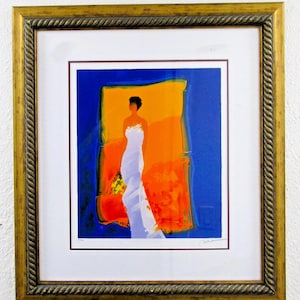 May include: Abstract art print in a gold frame. The artwork features a figure in a white dress against a backdrop of orange and blue. The frame has a rope-like texture. The print is mounted on a white mat.