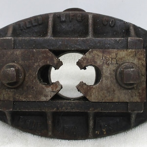 May include: A black cast iron pipe cutter with a 1 1/2R inscription. The cutter is made by the Reed Mfg. Co.