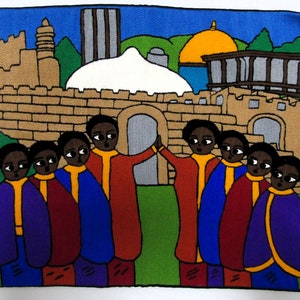 Könnte beinhalten: Eine farbenfrohe Tapisserie, die eine Gruppe von Menschen in traditioneller Kleidung vor einer ummauerten Stadt zeigt. Die Stadt verfügt über ein kuppelförmiges Gebäude und einen hohen Turm. Die Tapisserie ist aus gewebtem Stoff gefertigt und hat eine strukturierte Oberfläche.