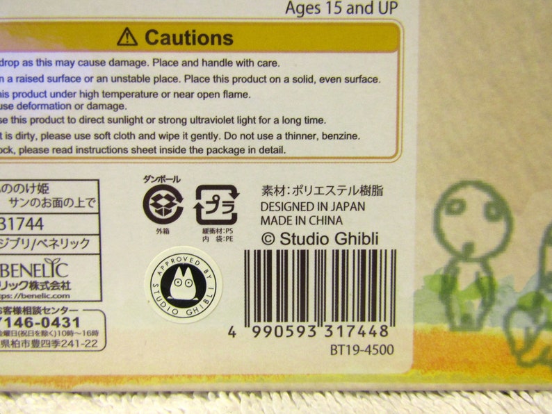 May include: A cardboard box with a yellow and brown design. The box features a cartoon character with large eyes and a small mouth. The box also includes the text "Studio Ghibli" and a barcode. The box is for ages 15 and up.