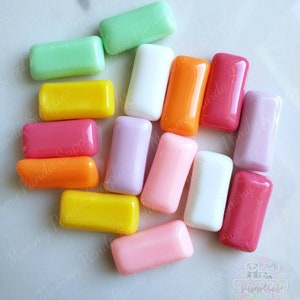 May include: Assortment of colorful rectangular shaped glass tiles in various colors including pink, orange, yellow, green, white, and purple.