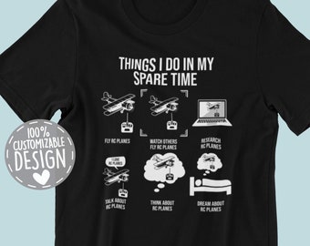 May include: Black t-shirt with a white graphic that says "Things I do in my spare time" and lists activities related to remote control airplanes. The graphic includes illustrations of airplanes, a remote control, a computer screen, and a sleeping person.