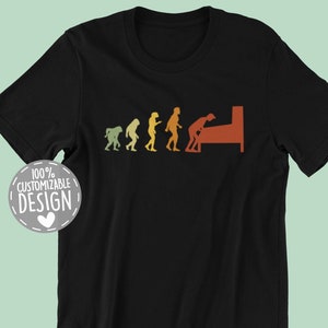 May include: Black t-shirt with a retro-style graphic of the evolution of man, culminating in a person playing pinball. The text "100% CUSTOMIZABLE DESIGN" is in a white circle with a heart.