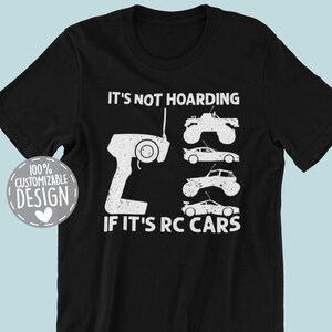 Peut inclure: T-shirt noir avec l'inscription "IT'S NOT HOARDING IF IT'S RC CARS" et un dessin d'une t&eacute;l&eacute;commande et de plusieurs mod&egrave;les de voitures RC. Comprend un logo "100% Customizable Design" et un logo "THE REALLY NICE STUFF".