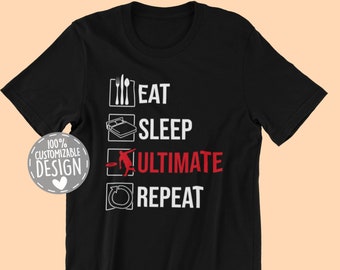 May include: Black t-shirt with white text that reads "Eat Sleep Ultimate Repeat" in a checklist format. The word "Ultimate" is in red.  The shirt has a small graphic of a person doing a backflip.