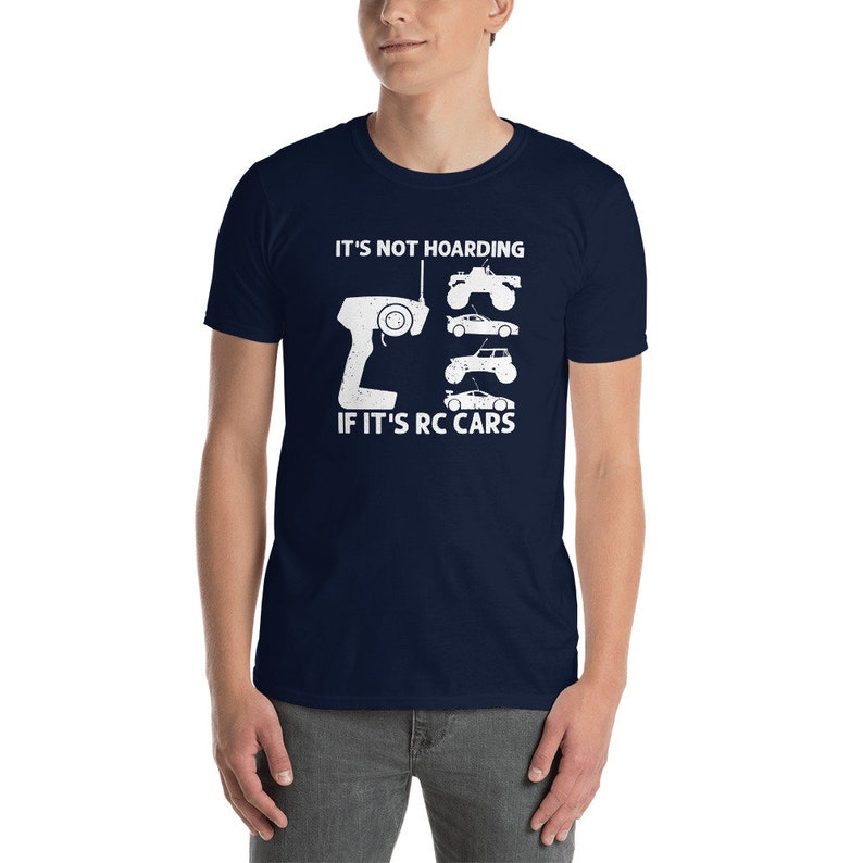 Peut inclure: T-shirt bleu marine avec un motif blanc. Le motif comprend une t&eacute;l&eacute;commande, quatre illustrations de voitures RC et le texte "IT'S NOT HOARDING IF IT'S RC CARS". Le t-shirt est fait d'une mati&egrave;re douce.