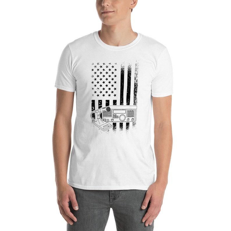 May include: White t-shirt with a black and white distressed American flag design. A radio transceiver is superimposed on the flag.