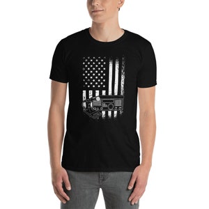 May include: Black t-shirt with a white distressed American flag design and a radio with a microphone on the bottom.