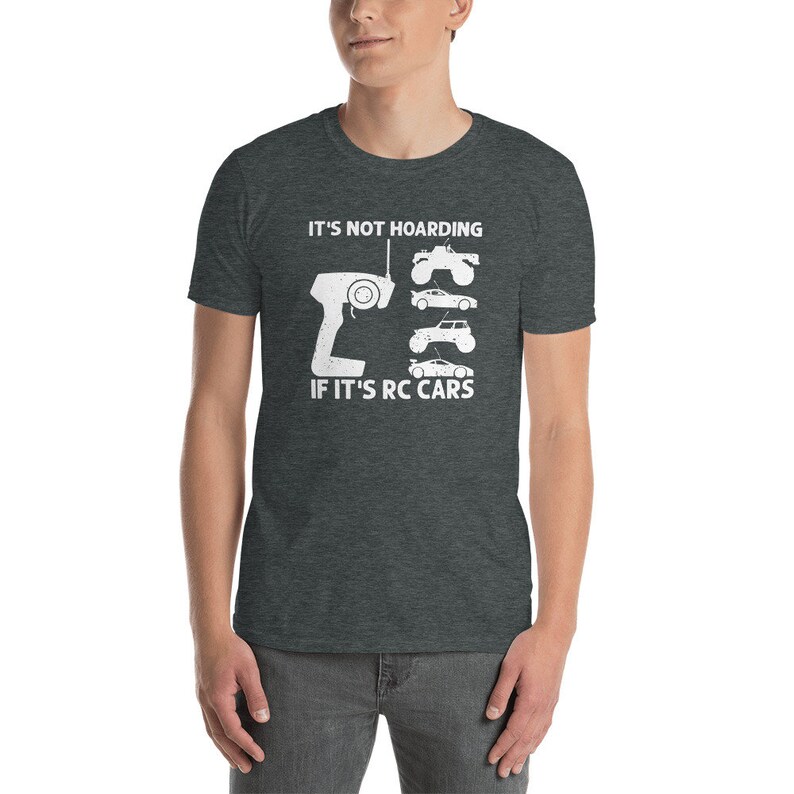 Peut inclure: T-shirt gris fonc&eacute; avec un motif blanc. Le motif comprend une t&eacute;l&eacute;commande, quatre illustrations de voitures RC et le texte "IT'S NOT HOARDING IF IT'S RC CARS."