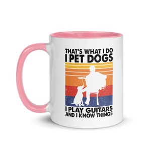 Puede incluir: Taza de caf&eacute; blanca con borde rosa. La taza tiene un gr&aacute;fico de estilo retro con una persona tocando la guitarra y un perro. El texto dice "That's what I do I pet dogs I play guitars and I know things."