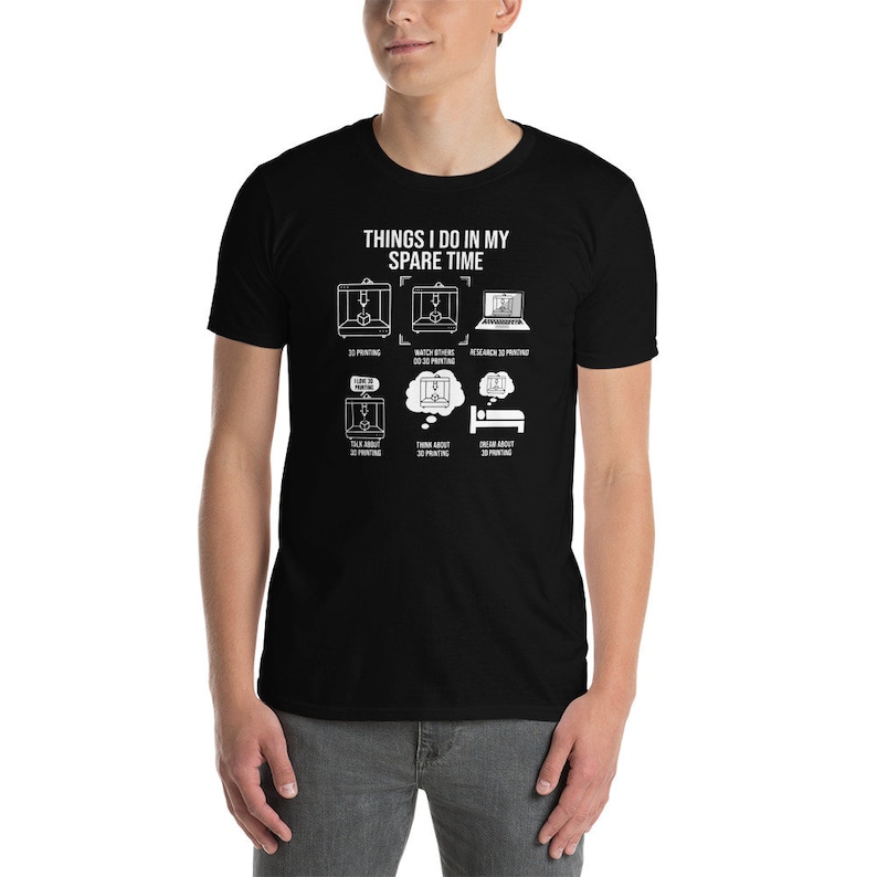 Puede incluir: Una camiseta negra con texto blanco que dice "Things I do in my spare time". El texto est&aacute; rodeado de ilustraciones de impresoras 3D y una persona durmiendo.