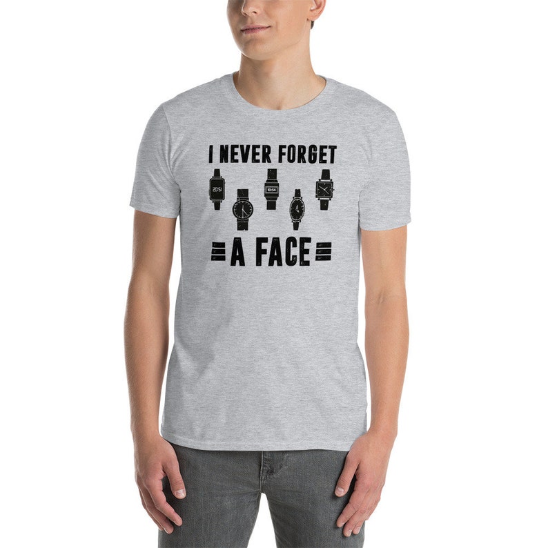 Puede incluir: Una camiseta gris con texto negro que dice "Nunca olvido = una cara =" y presenta una fila de cinco caras de reloj diferentes.