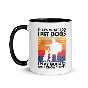 Puede incluir: Taza de caf&eacute; de cer&aacute;mica blanca con borde y asa negros. La taza presenta un gr&aacute;fico de estilo retro con una persona tocando la guitarra y un perro sentado a su lado. El texto dice "That's what I do I pet dogs I play guitars and I know things".