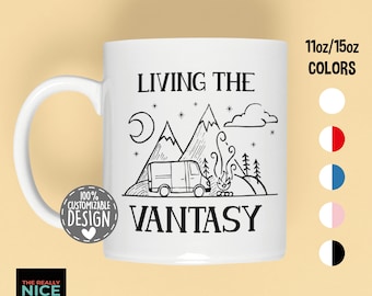 May include: White ceramic mug with a black and white illustration of a camper van, mountains, a campfire, and stars. The text "LIVING THE VANTASY" is printed on the mug. The mug is available in 11oz or 15oz sizes and in various colors.