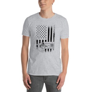 May include: A heather grey t-shirt with a distressed American flag design and a black and white illustration of a radio transceiver.