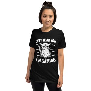 May include: Black t-shirt with a white graphic of a cat wearing headphones and holding a video game controller. The text "Can't hear you I'm gaming" is printed on the shirt.