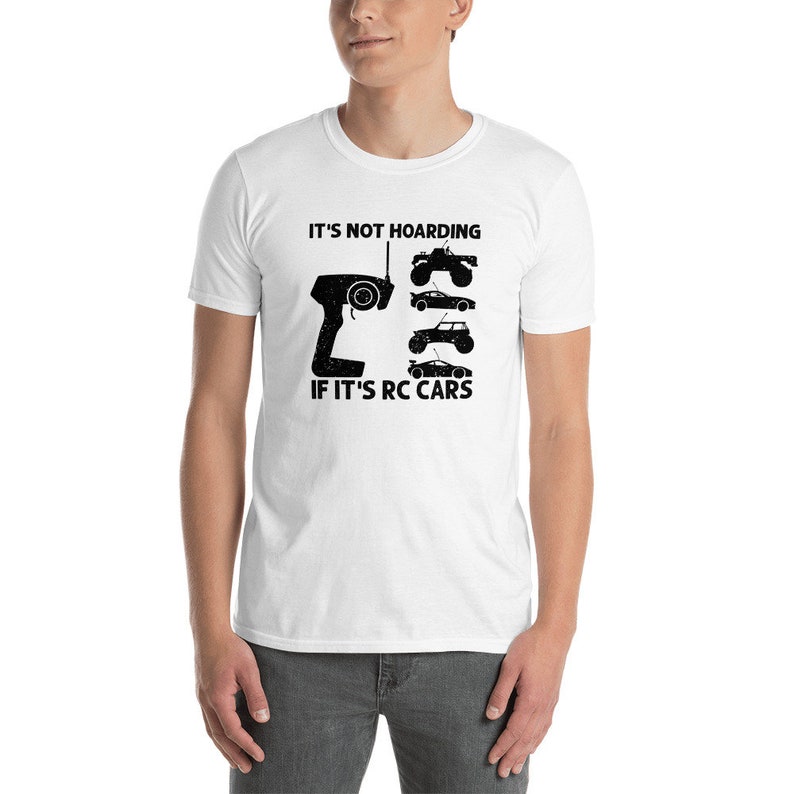 Peut inclure: T-shirt blanc avec un motif noir repr&eacute;sentant une t&eacute;l&eacute;commande et des silhouettes de voitures RC. Le texte indique : &laquo; CE N'EST PAS DE L'ACCUMULATION SI CE SONT DES VOITURES RC &raquo;.
