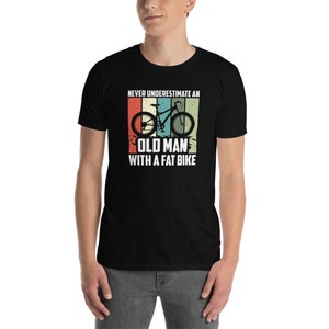 May include: Black t-shirt with a vintage-style graphic of a mountain bike and the text "Never underestimate an old man with a fat bike."