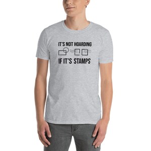 Puede incluir: Una camiseta gris con el texto "No es acaparamiento si son sellos" y un gr&aacute;fico de tres sellos postales.
