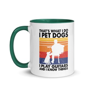 Puede incluir: Taza de caf&eacute; de cer&aacute;mica blanca con borde verde. La taza presenta un gr&aacute;fico de estilo retro de una persona tocando la guitarra con un perro sentado a su lado. El texto en la taza dice "That's what I do I pet dogs I play guitars and I know things."