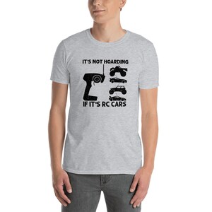 Peut inclure: T-shirt gris clair avec l'inscription noire "IT'S NOT HOARDING IF IT'S RC CARS". Le t-shirt pr&eacute;sente un graphique d'une t&eacute;l&eacute;commande de voiture RC et de plusieurs mod&egrave;les de voitures RC.