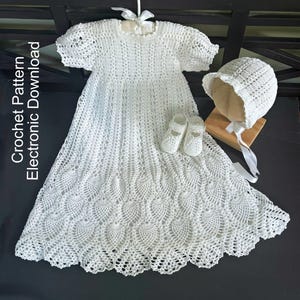 May include: A white crochet dress with short puff sleeves, a matching bonnet with a white ribbon tie, and a pair of small crochet shoes. The text Crochet Pattern Electronic Download is visible on the left side of this white handmade garment set.