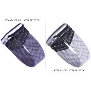 May include: Two Apple Watch bands in a braided style, one in dark gray and one in light gray. Both bands have a black leather strap with a white stitching detail.
