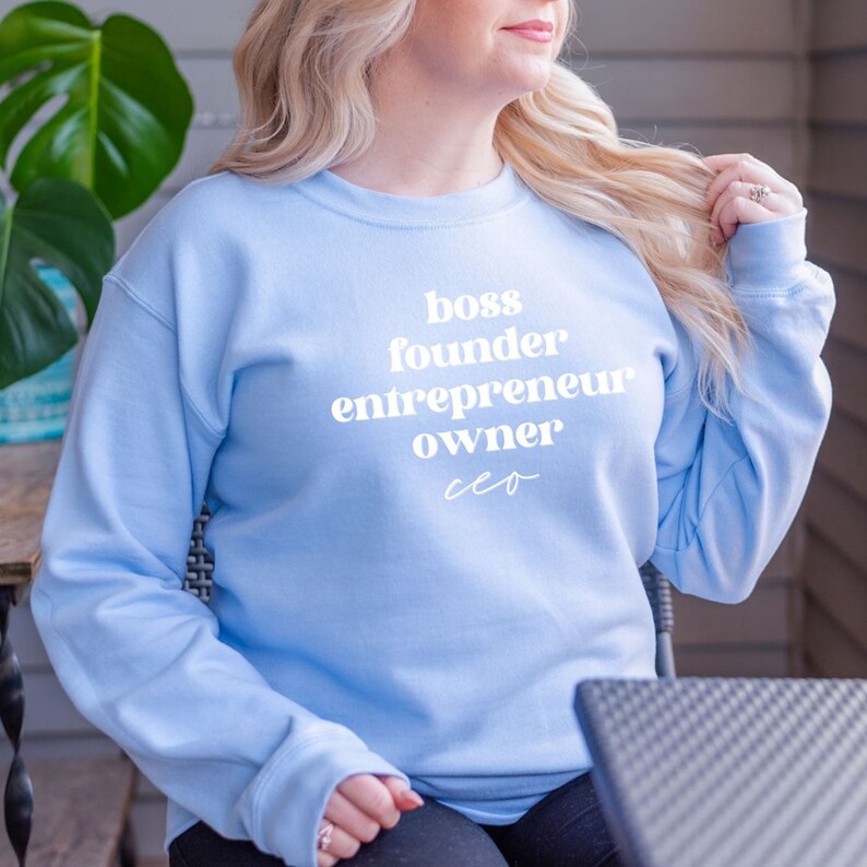 May include: A light blue sweatshirt with the text "boss founder entrepreneur owner ceo" printed in white.