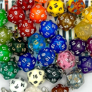 May include: A collection of twenty-sided polyhedral dice charms in various colours including red, blue, green, yellow, orange, purple, white, and black. Each die features white or black numbers and is attached to a small silver metal lobster clasp.